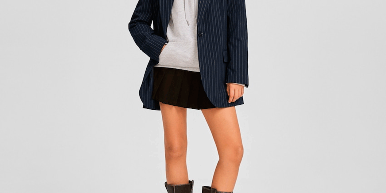 La faldilla mini de taules que les noves 'pijes' porten amb esportives i mitjó alt és a Bershka