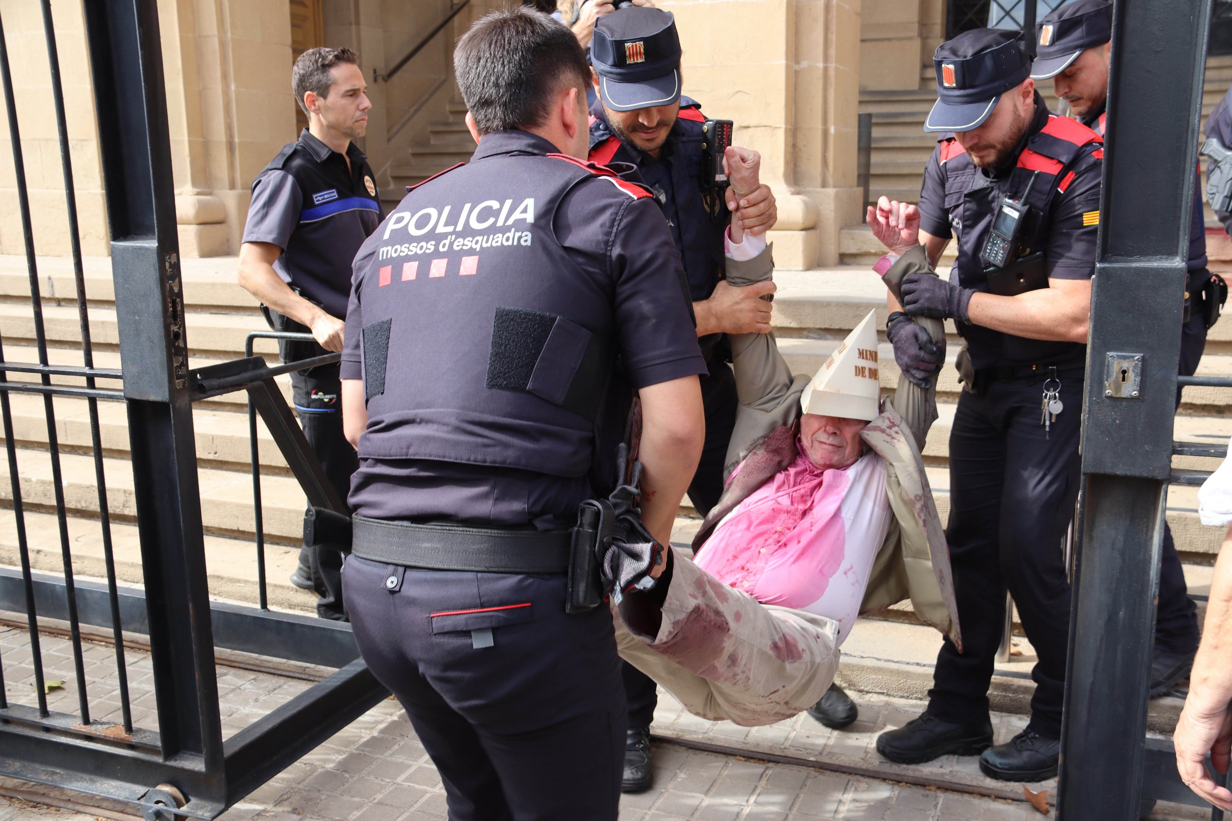Pacifistes protesten contra Pedro Sánchez amb sang falsa a Barcelona i els Mossos els desallotgen