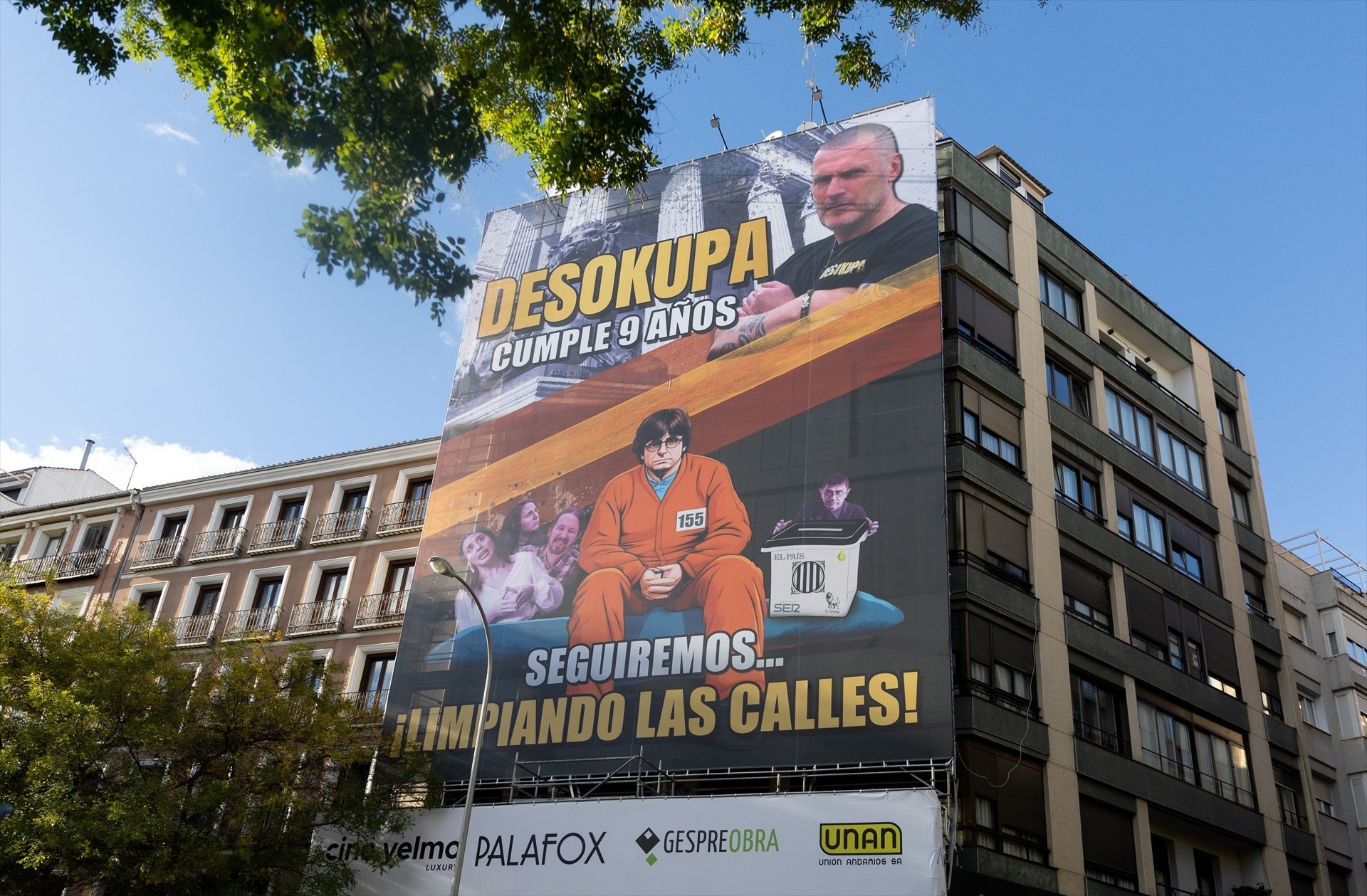 Desokupa viste a Puigdemont de prisionero en una pancarta gigante en el centro de Madrid