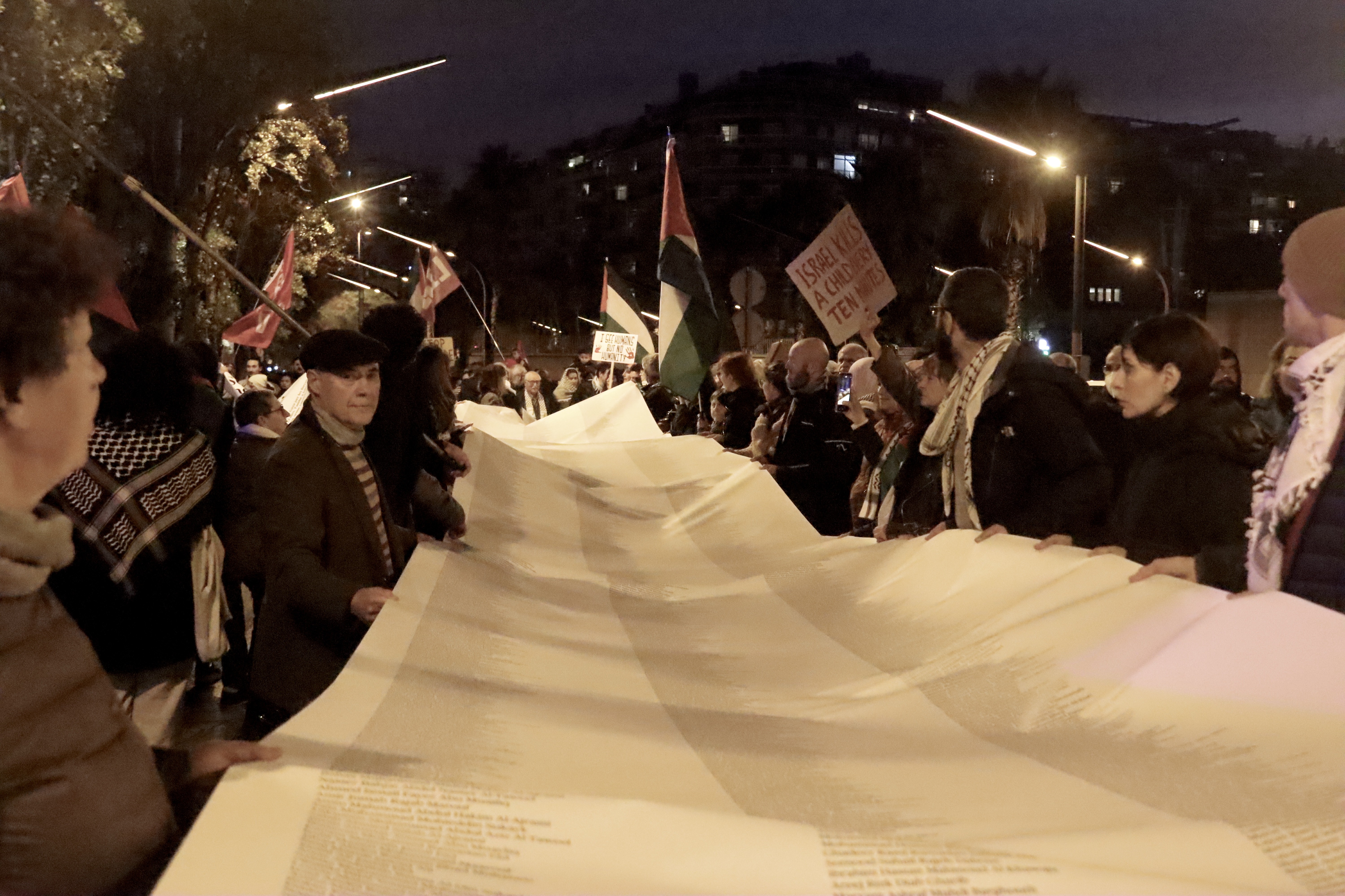 Manifestantes despliegan una lista de personas asesinadas en Gaza delante del consulado de Israel en Barcelona
