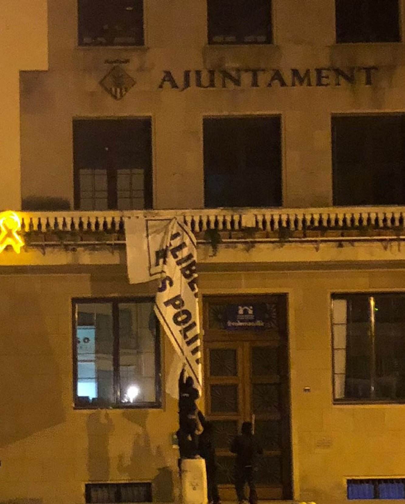 Uns encaputxats retiren els símbols pels presos polítics de l'Ajuntament de la Garriga