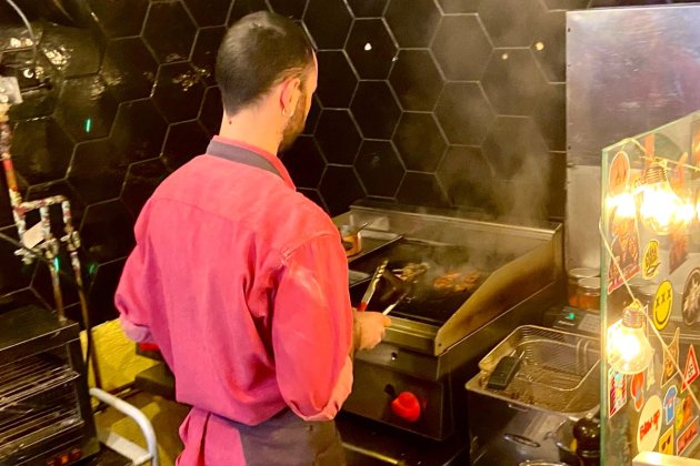 Des de la taula pots veure en Simone cuinant al moment els entrepans