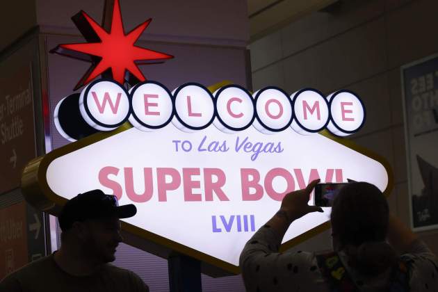 Aficionados obsreven un cartel de la Super Bowl 2024 en Las Vegas / Foto: EFE