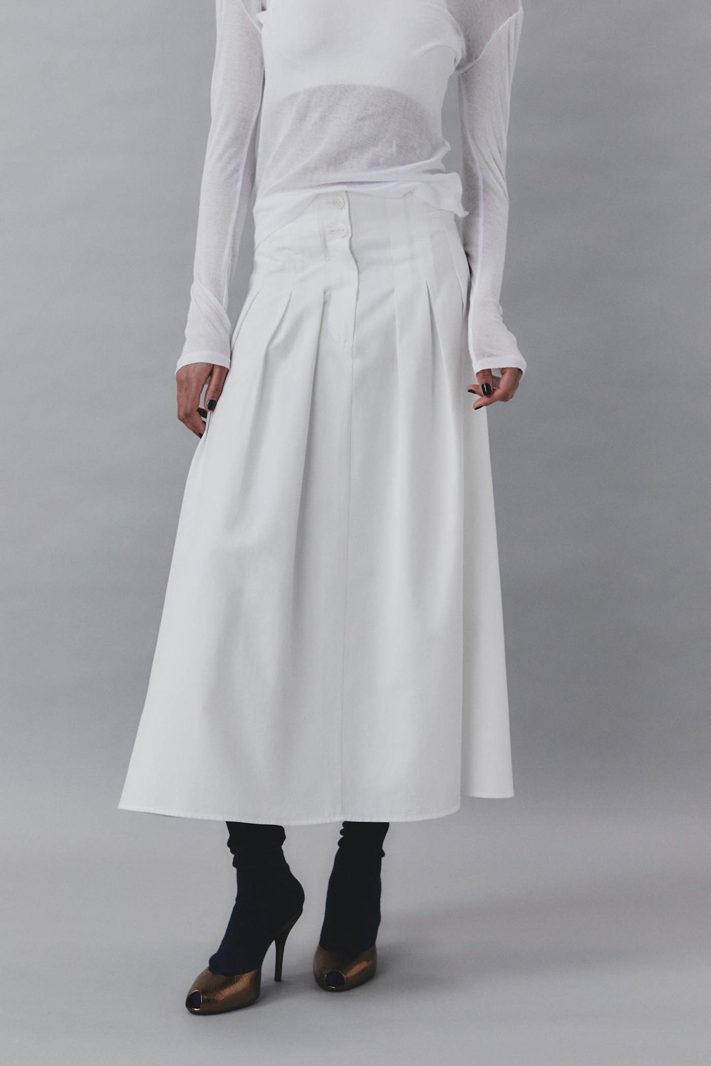 El color blanco de la nueva falda midi de tablas de Sfera nos ha robado el corazón