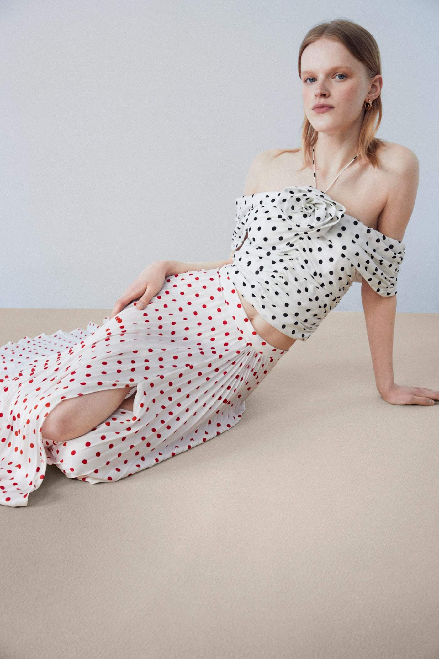 Esta falda plisada blanca repleta de lunares de Sfera rejuvenece tus looks
