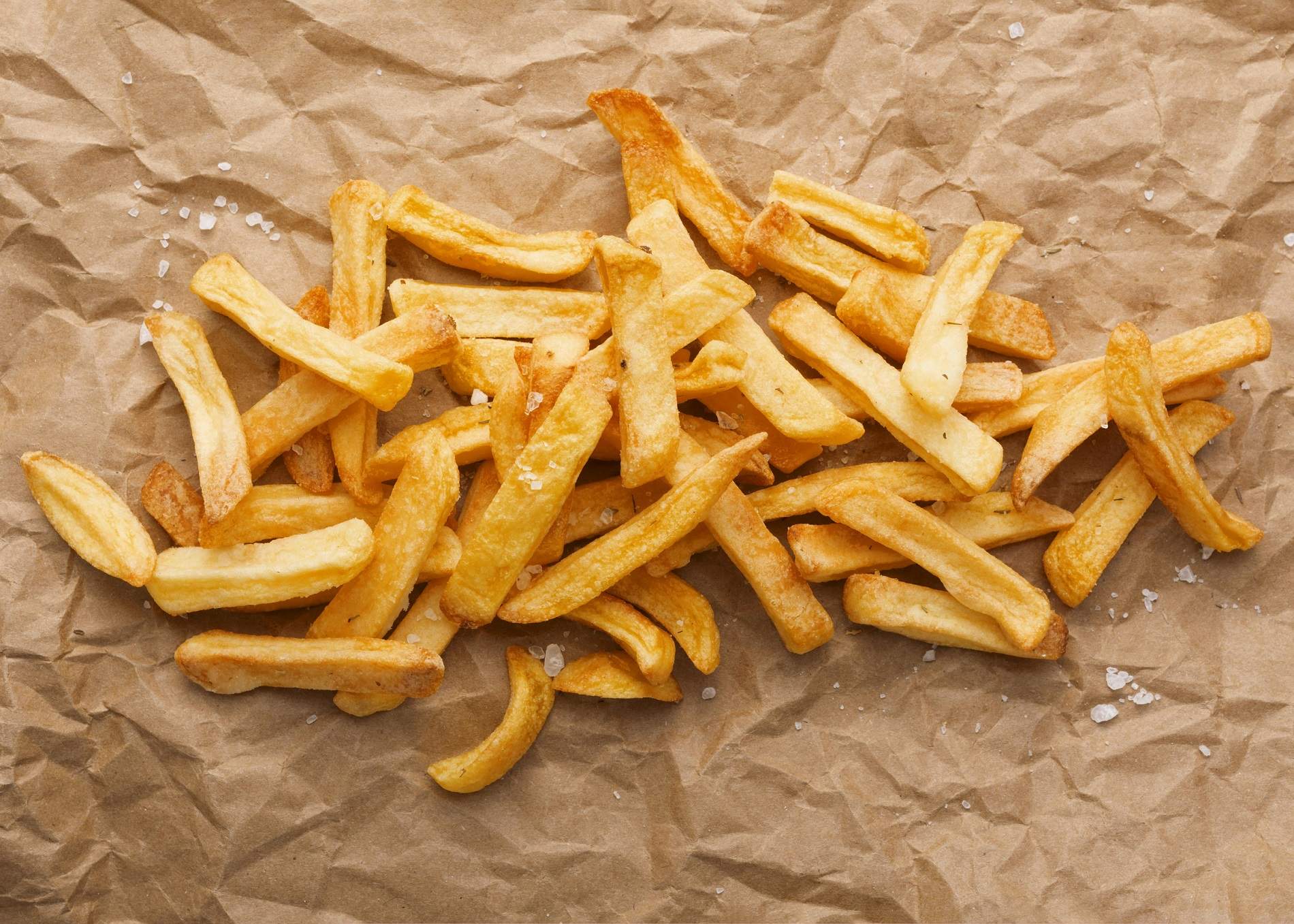 top view french fries with salt paper