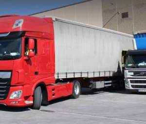 Camiones cargando mercancías en una plataforma logística. TDRJobs Camiones cargando mercancías en una plataforma logística. TDRJobs