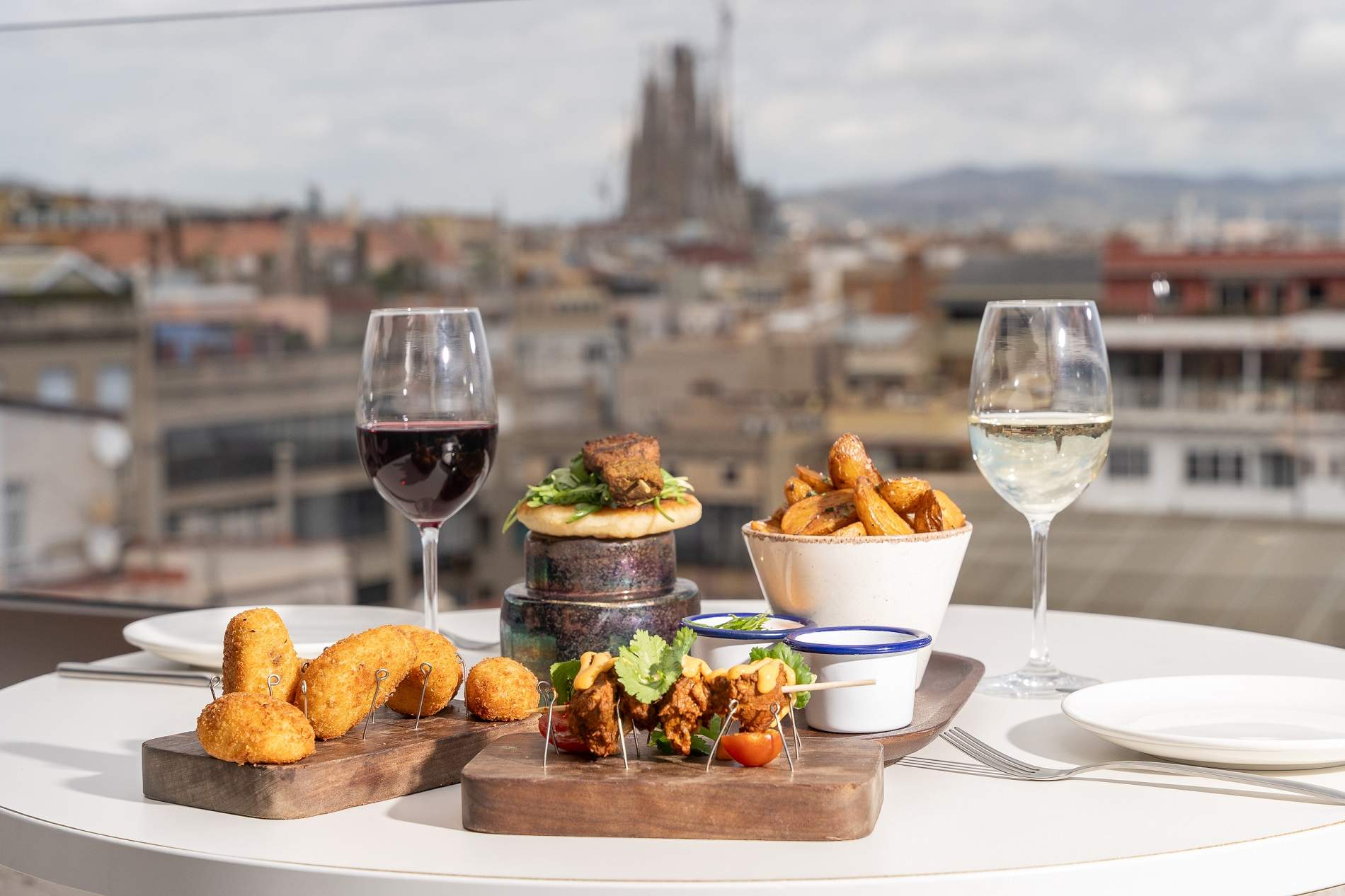 Un restaurant mundial amb platets a una terrassa aèria amb vistes a la Sagrada Família