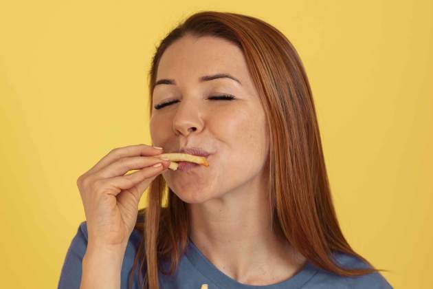 front view young woman eating fries front view young woman eating fries
