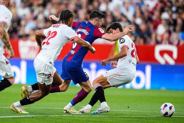 Lewandoski con dos jugadores del Sevilla / Foto: Europa Press