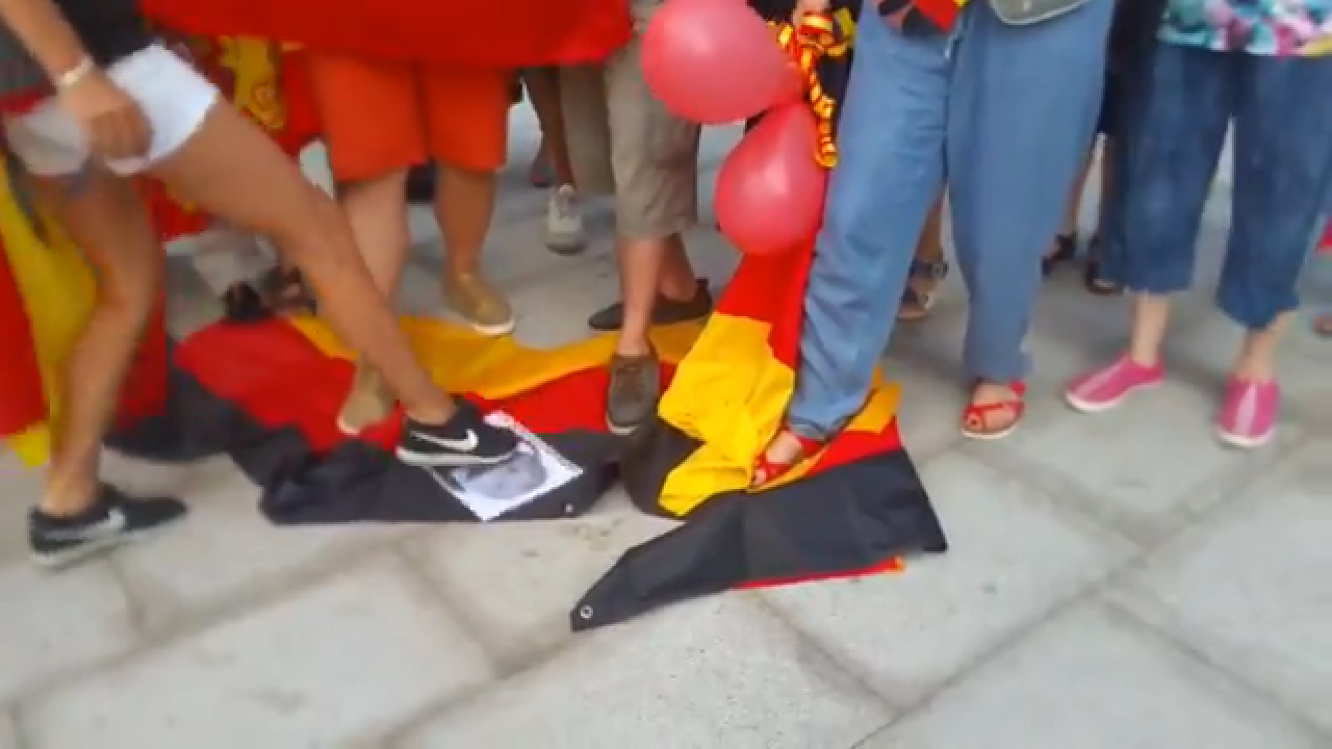 Far-right protesters trample on German flag in front of consulate in Barcelona