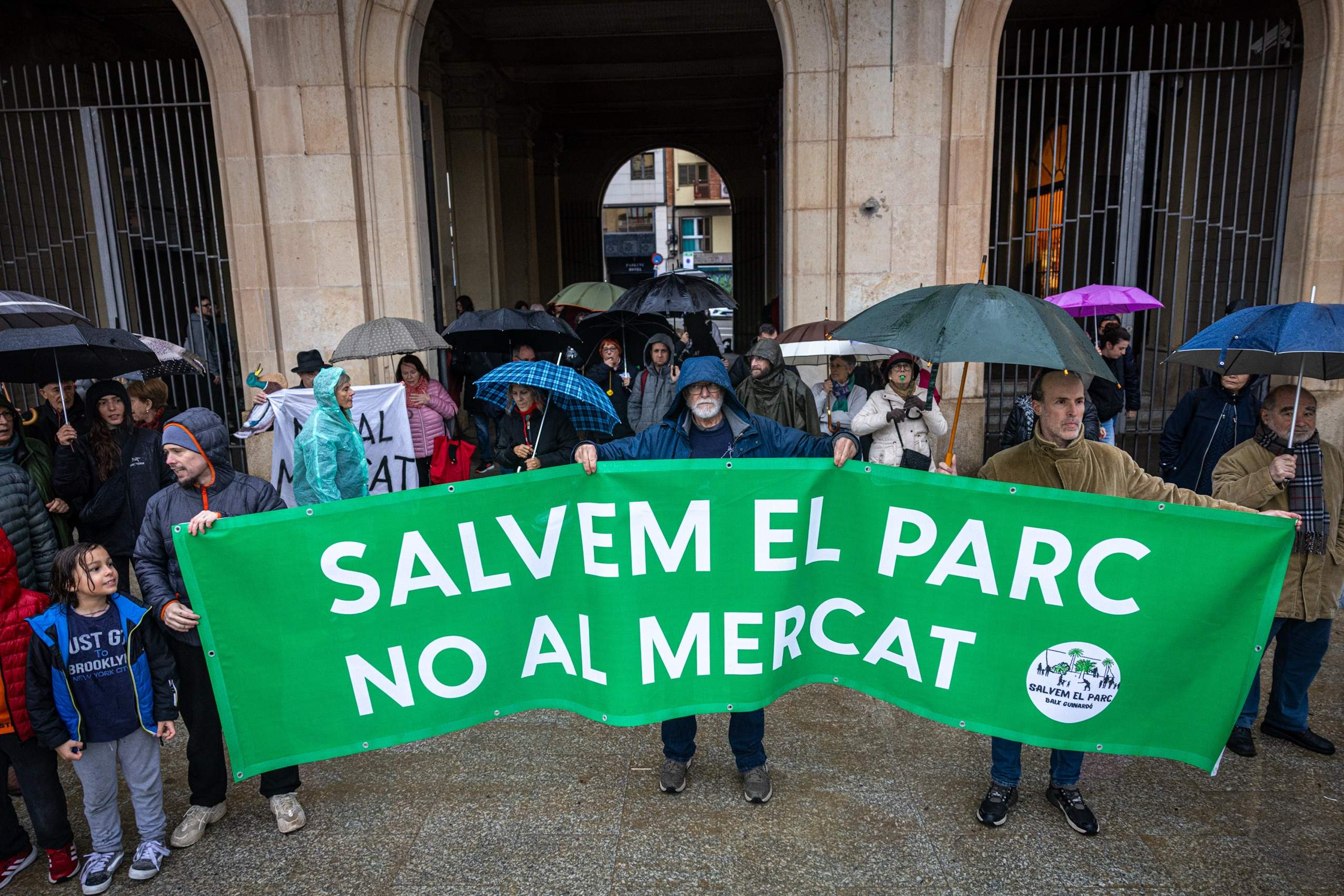 Protesta sota la pluja contra la ubicació provisional del Mercat de l'Estrella als Jardins del Baix Guinardó