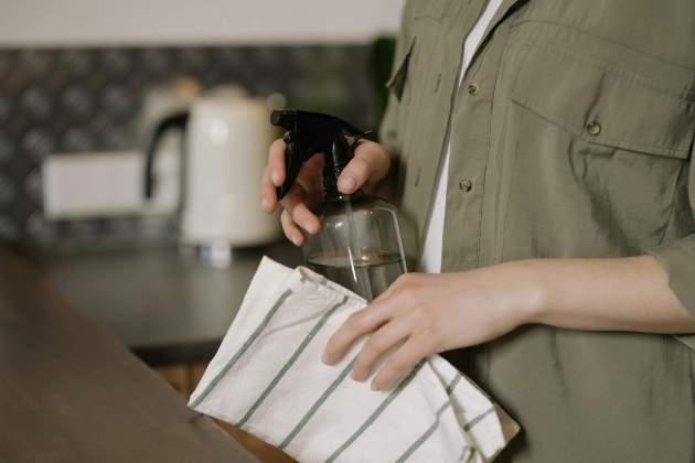 Persona netejant un taulell. Foto: Pexels