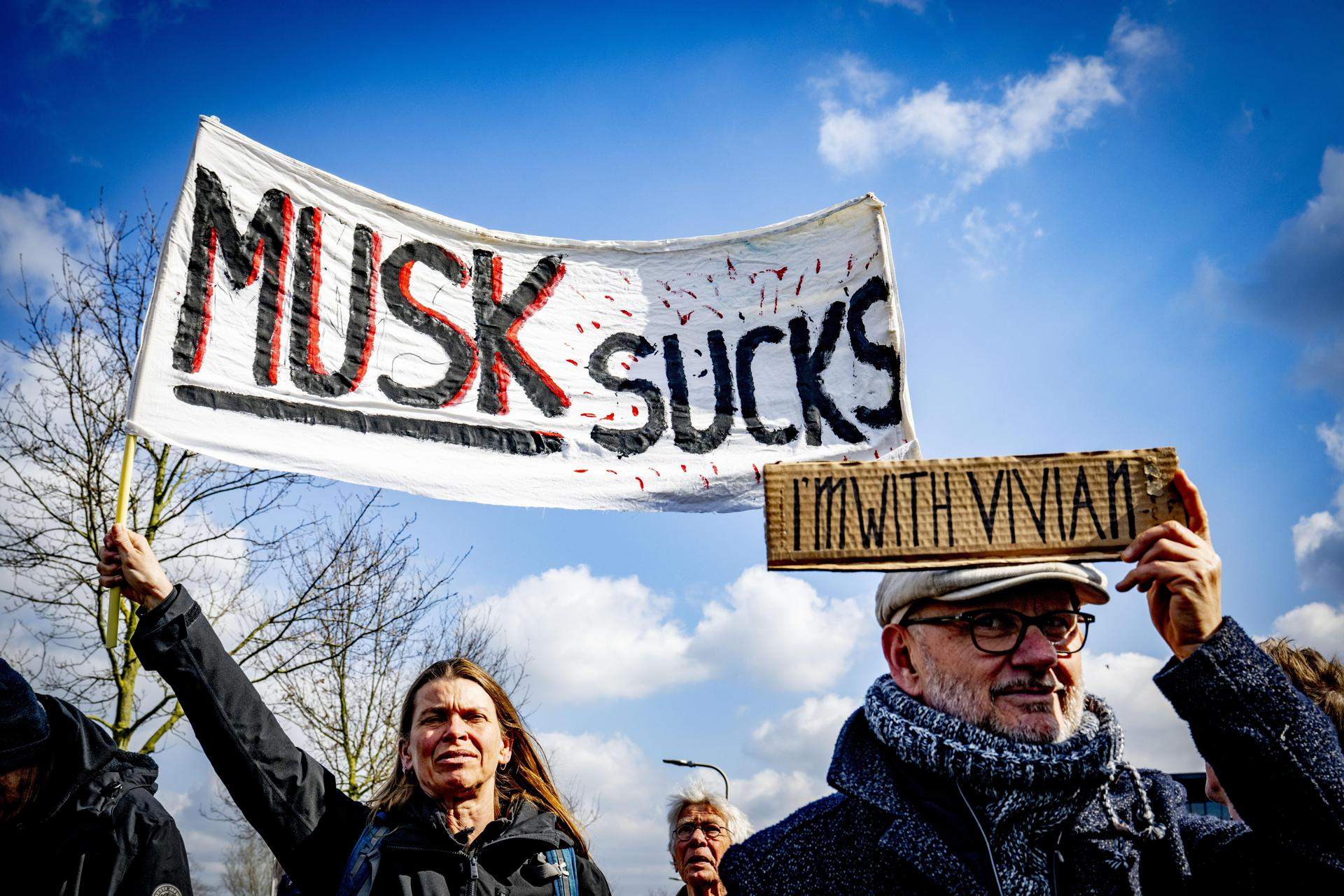 Manifestantes anti-Musk con una pancarta que dice Manifestantes anti-Musk con una pancarta que dice