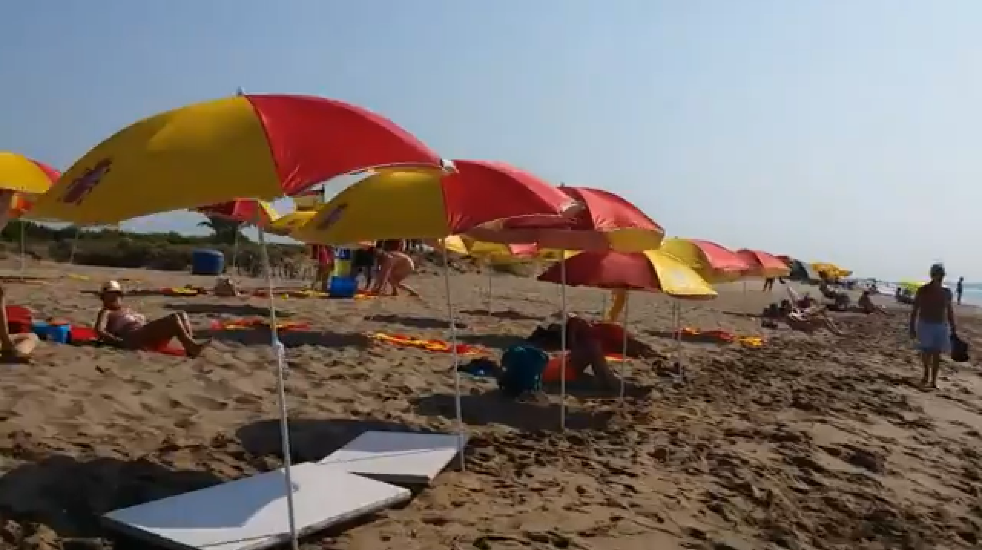 Ocupan la playa del Prat con parasoles y toallas con la bandera española