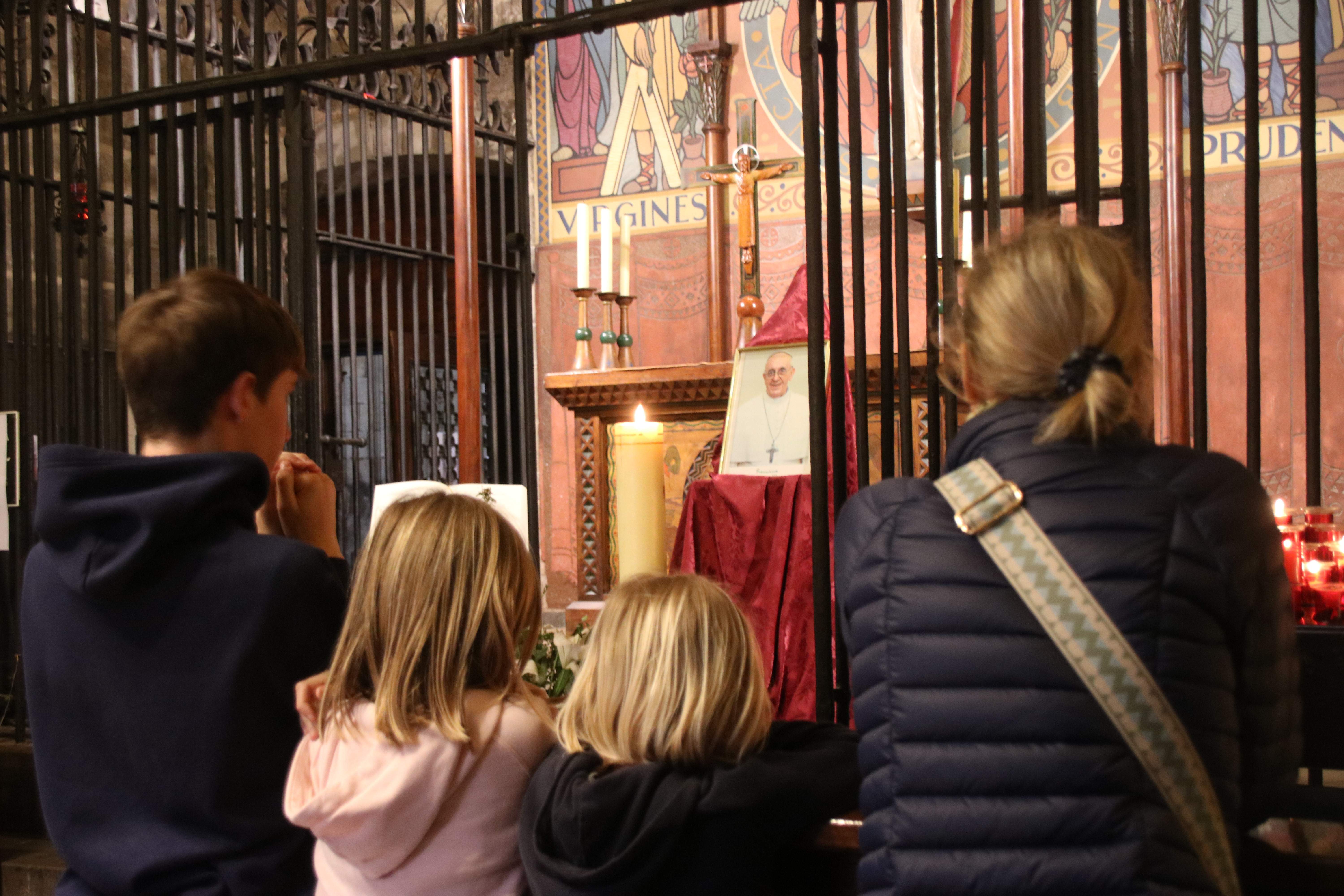 Una família prega per al papa Francesc a la capella de Santa Llúcia