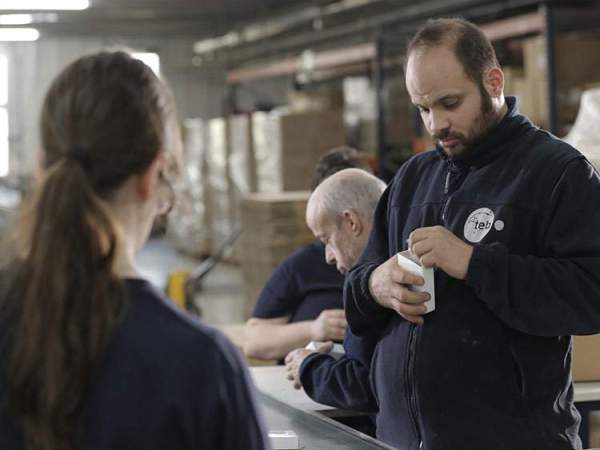 trabajadores de la cooperativa TEB, en un procés|proceso de envasado.
