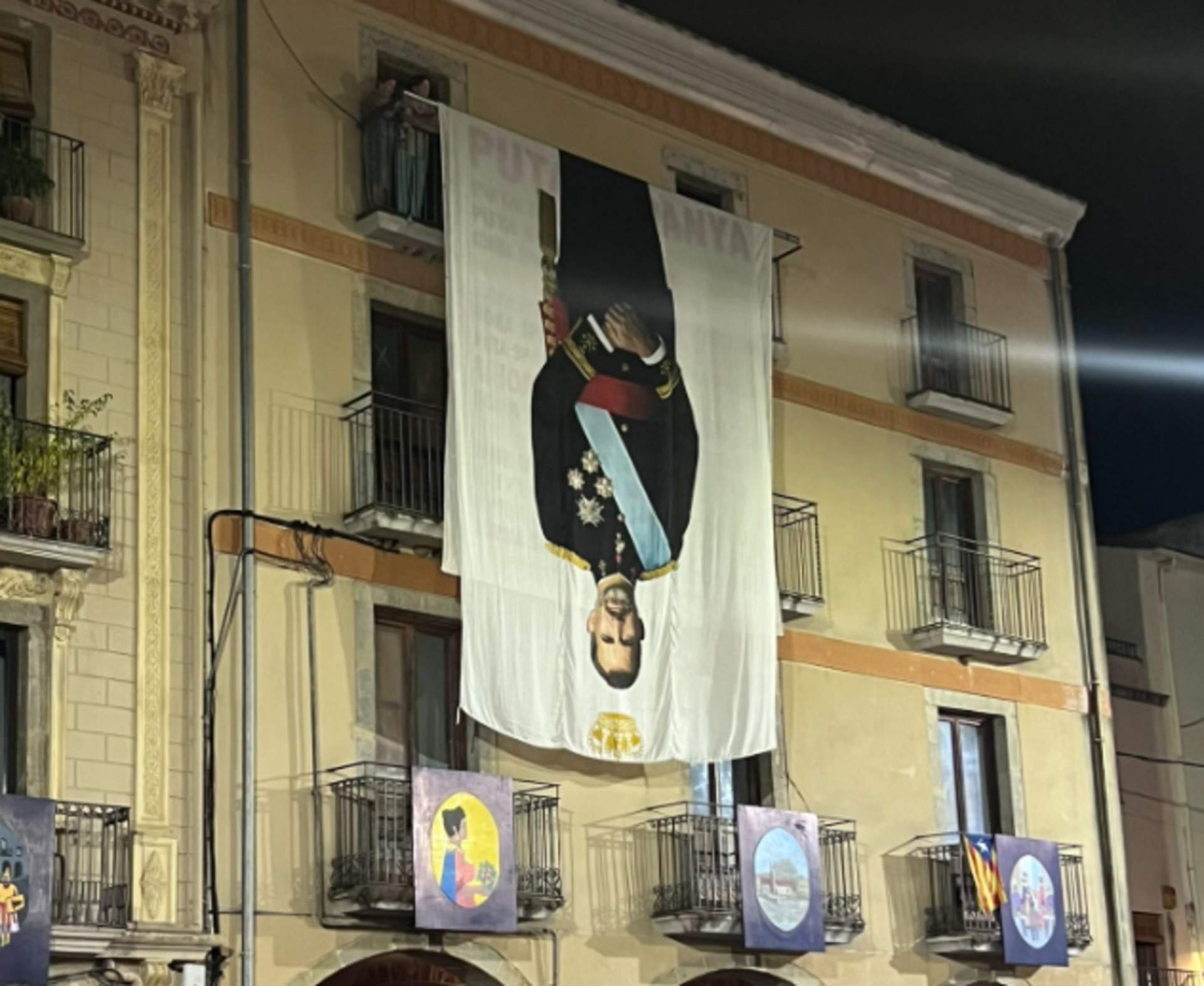 Una pancarta gegant de Felip VI cap per avall, protagonista a la festa major d'Amer, poble de Puigdemont