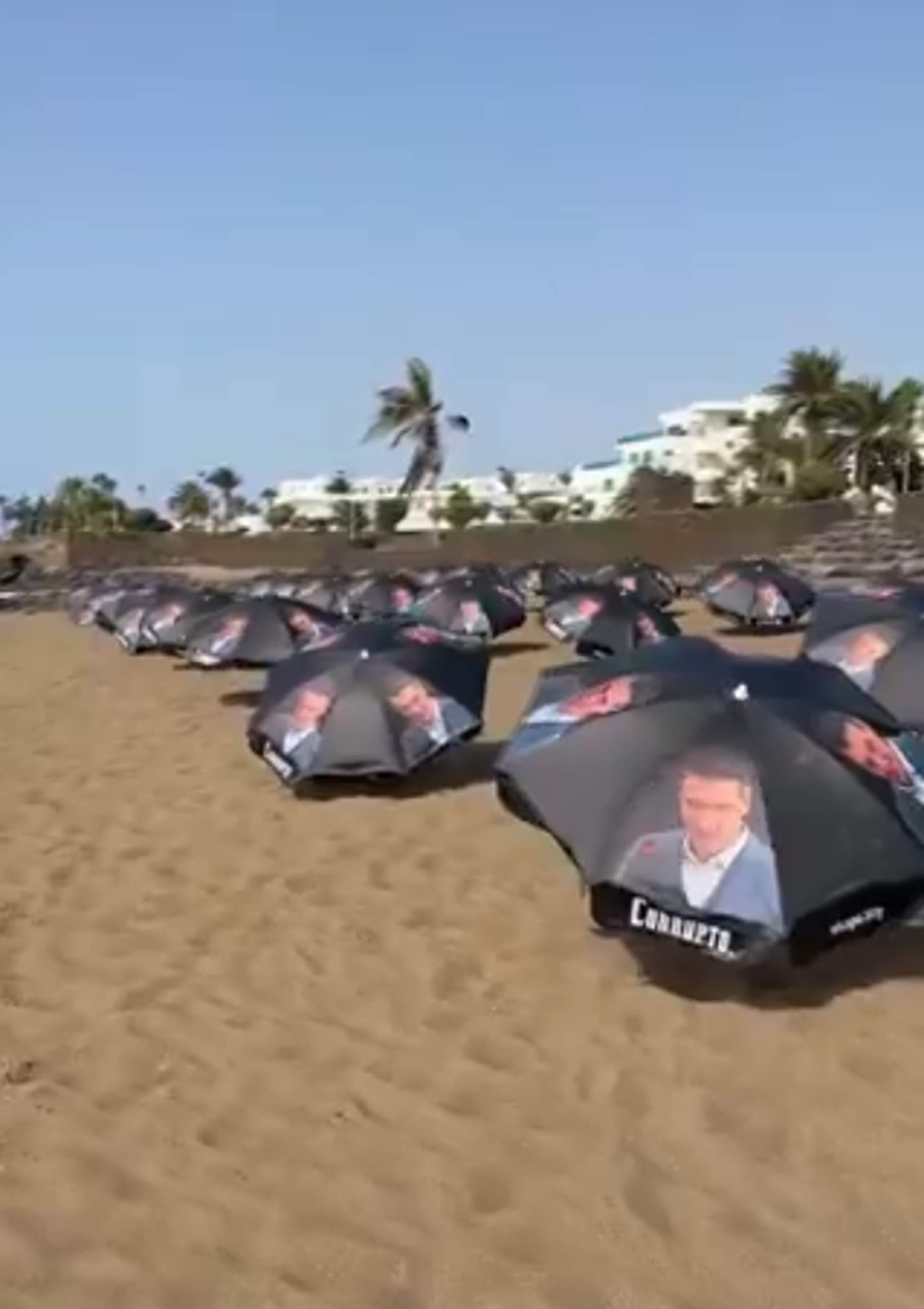 Hazte Oir omple una platja de Lanzarote amb para-sols amb la cara de Pedro Sánchez