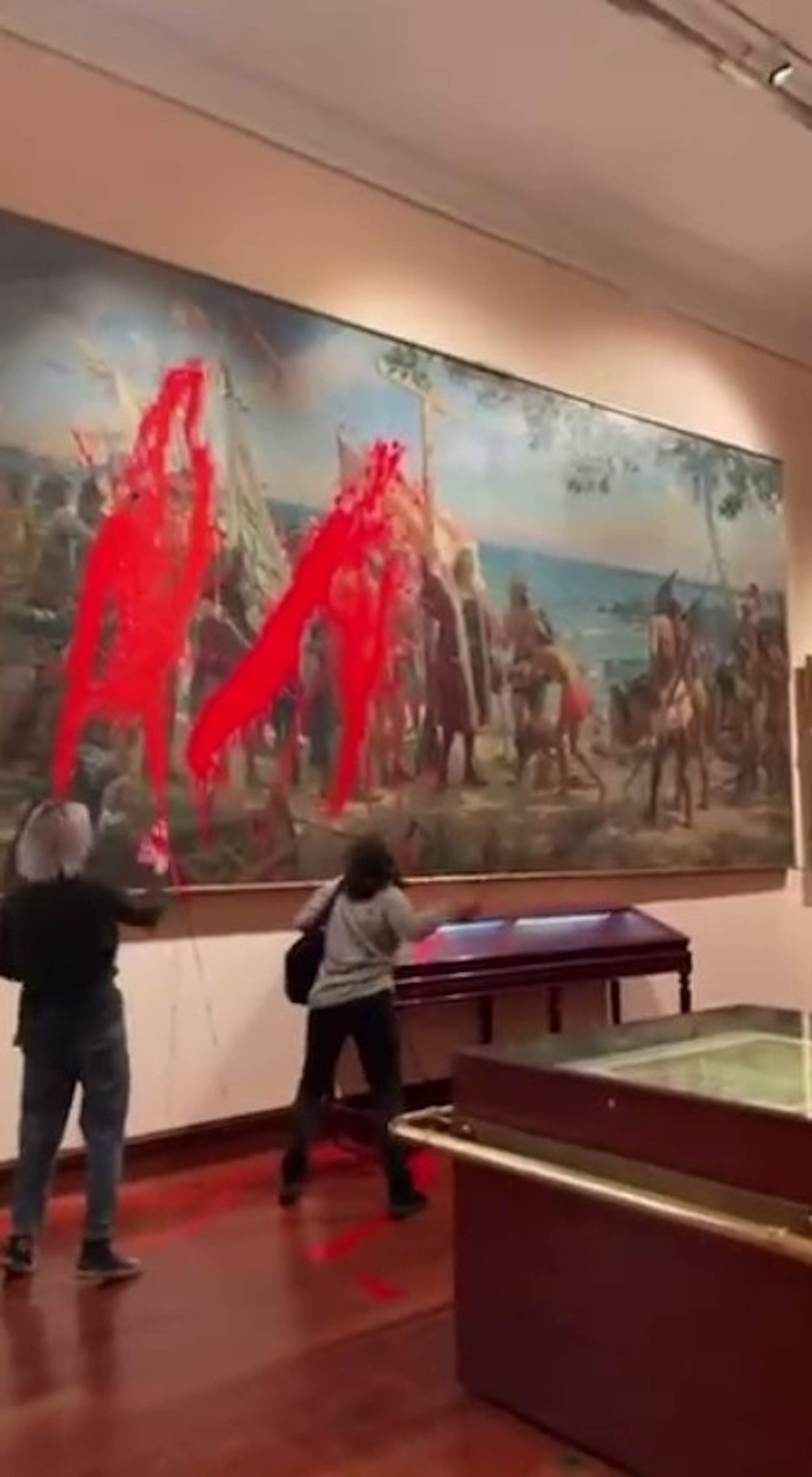 Dos activistas rocían con pintura un cuadro de Cristóbal Colón en el Día de la Hispanidad | VÍDEO
