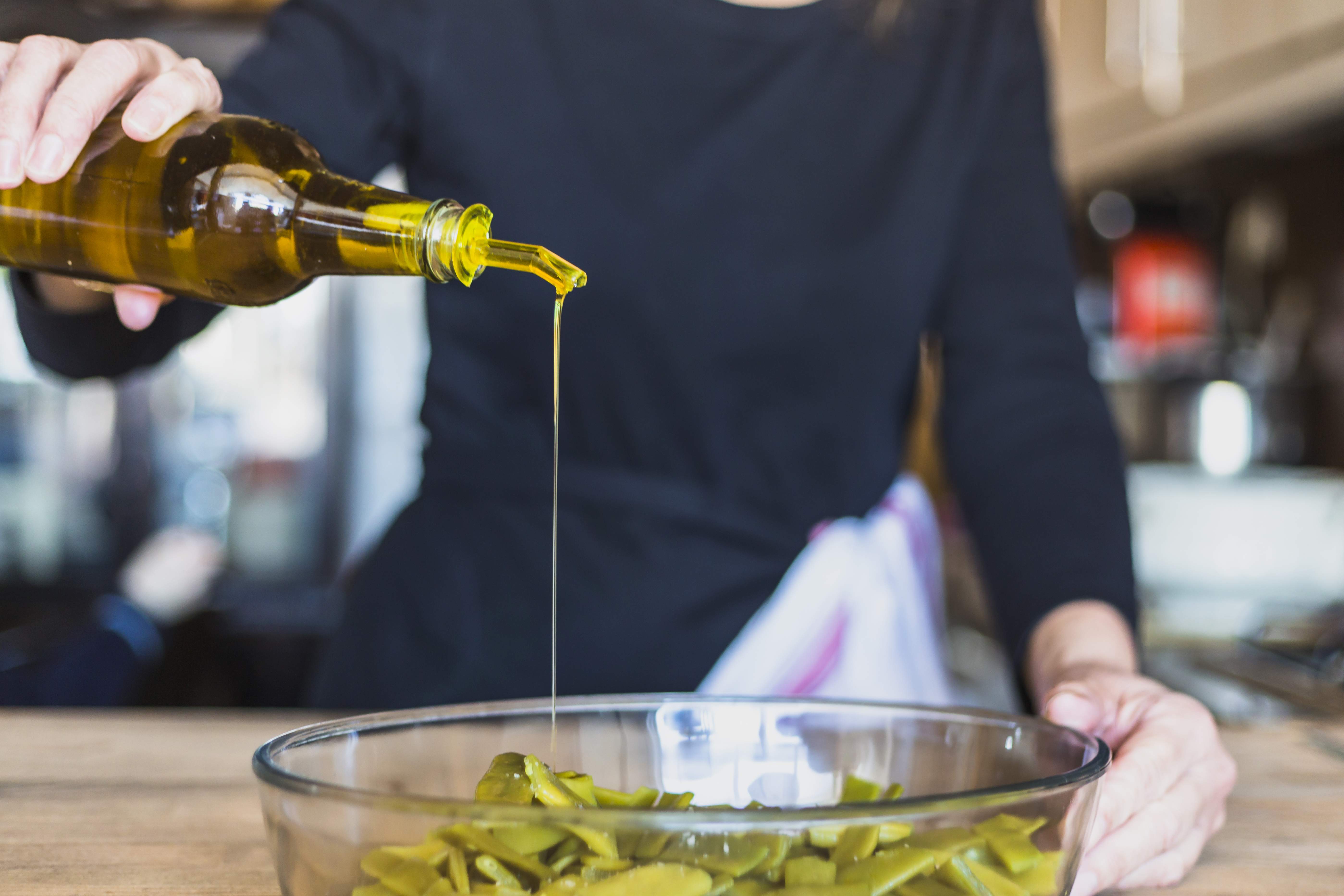 recortar las manos de mujer cocinando ensalada en la cocina