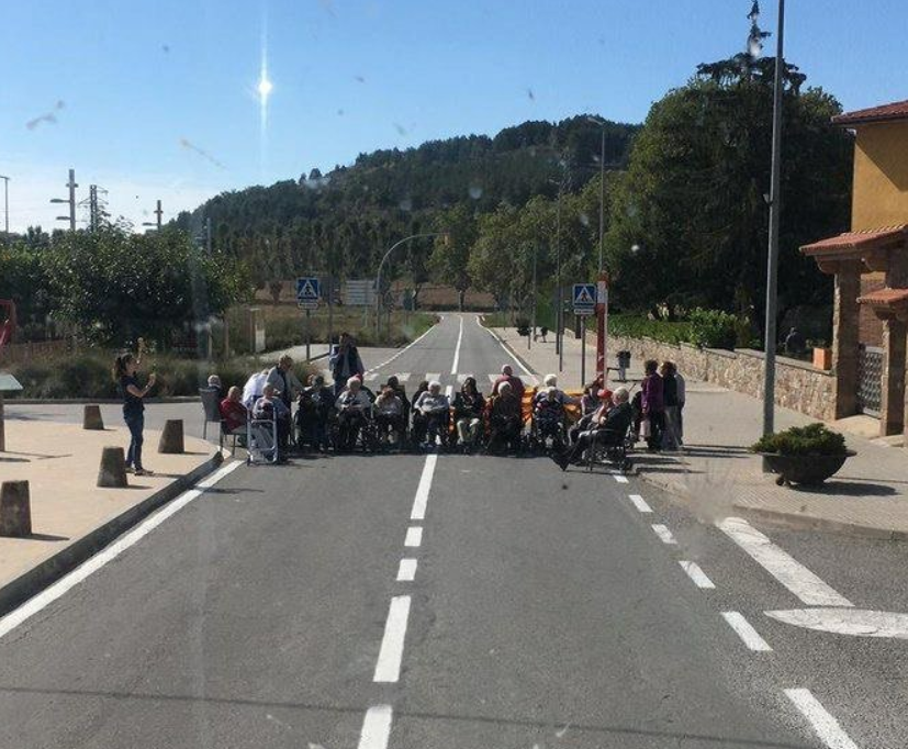 Jubilados con silla de ruedas cortan una carretera por el 1-O