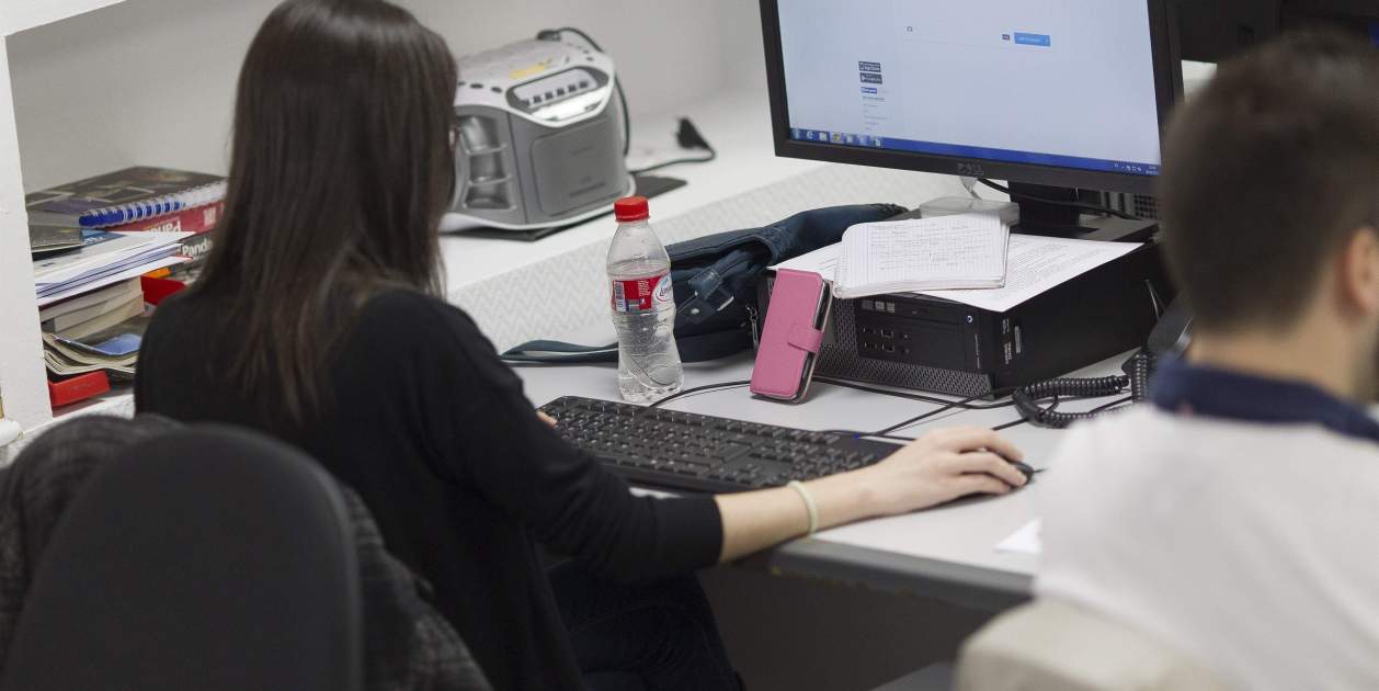 Una persona trabaja en una oficina con un ordenador.