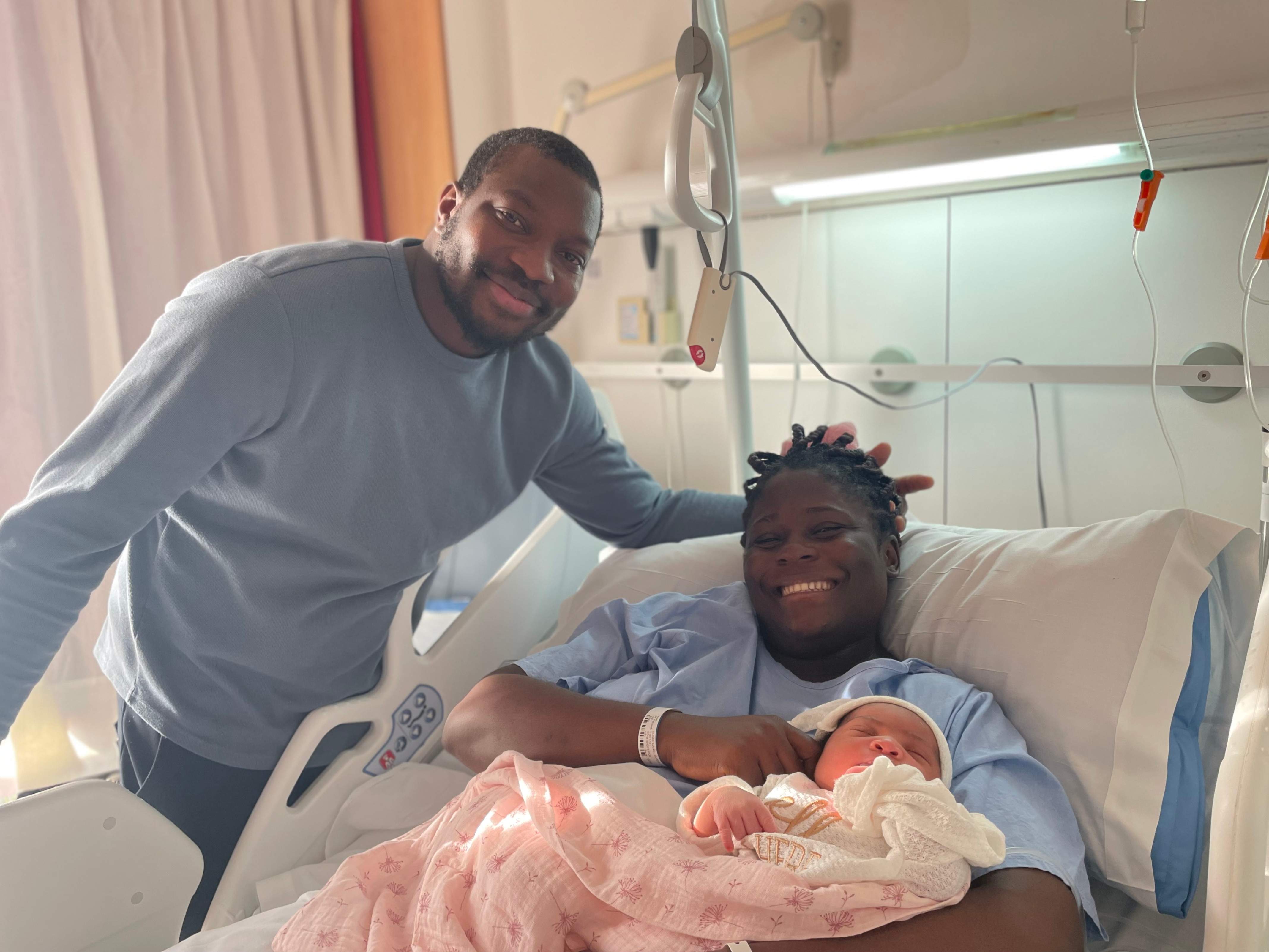 L'Alda Joana en braços de la seva mare, Clodia Isabel, i al costat del seu pare, Michel L'Alda Joana en braços de la seva mare, Clodia Isabel, i al costat del seu pare, Michel