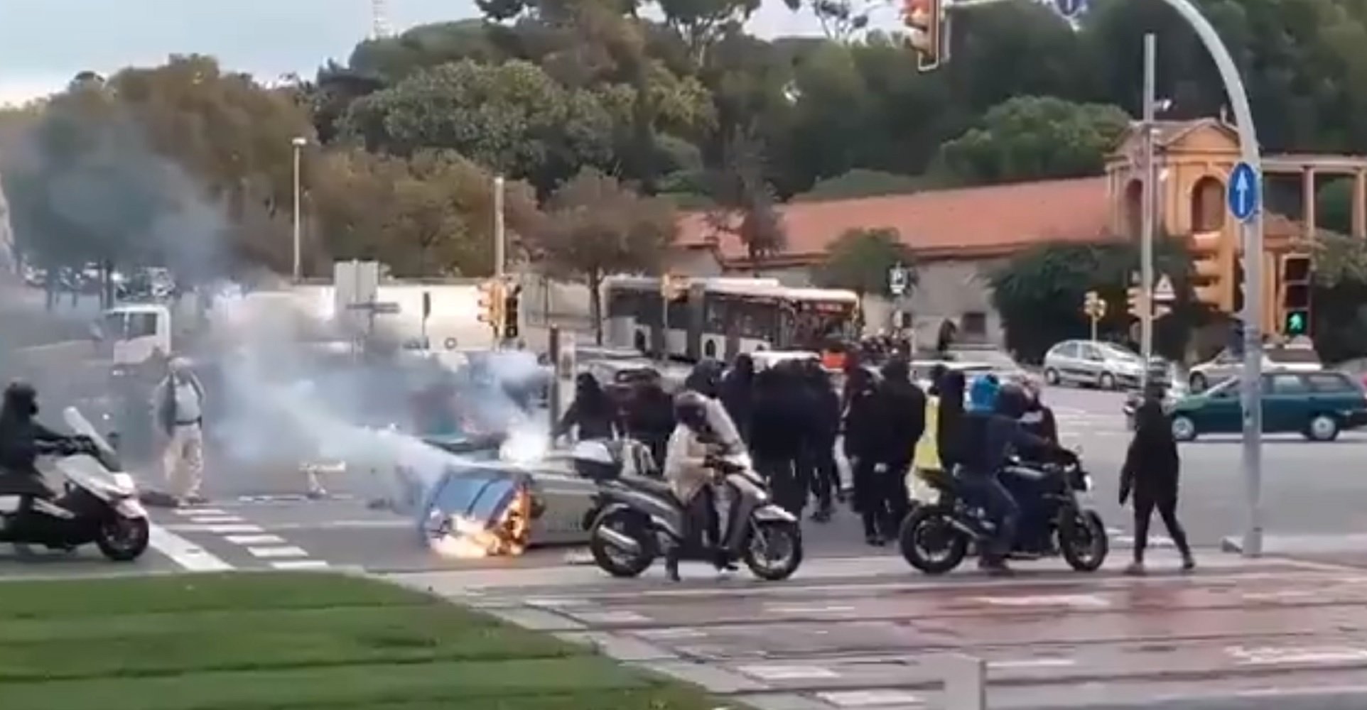 Un grup d'okupes crema contenidors i pneumàtics al mig de la Diagonal