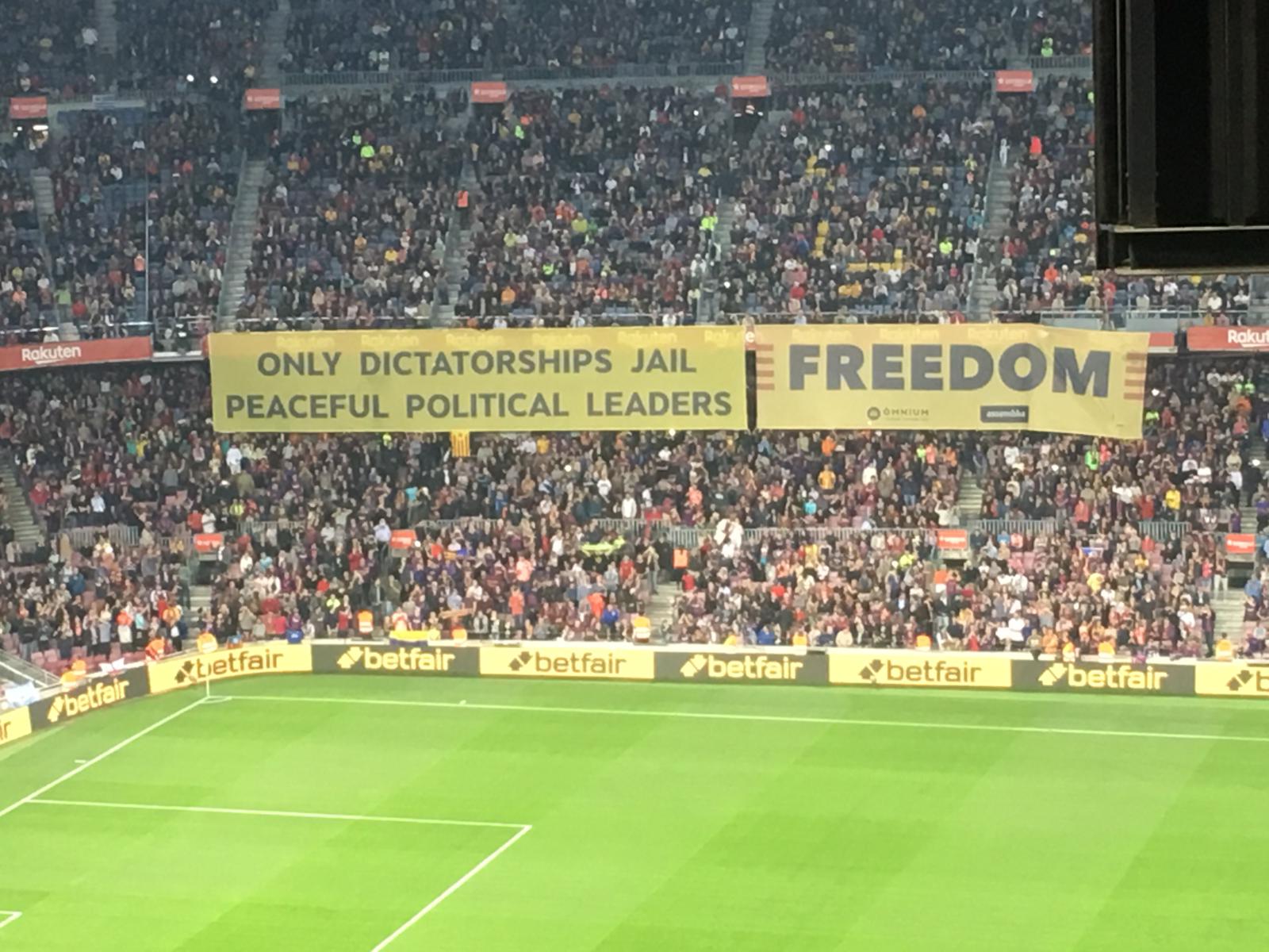 "Sólo las dictaduras encarcelan a líderes políticos pacíficos", en una pancarta del Camp Nou