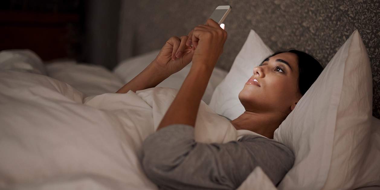 Usando el movil en la cama