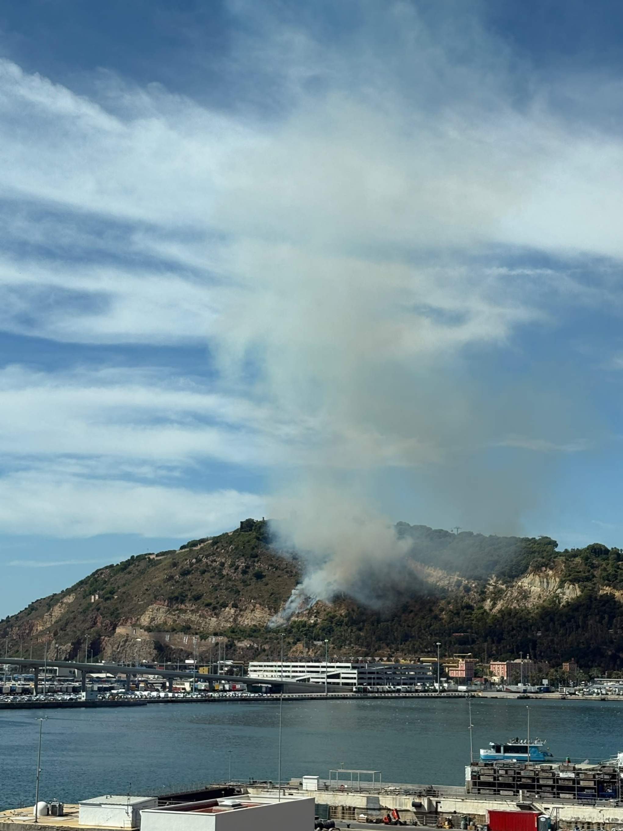 Un incendio en Montjuïc quema parte de la montaña y levanta una gran columna de humo