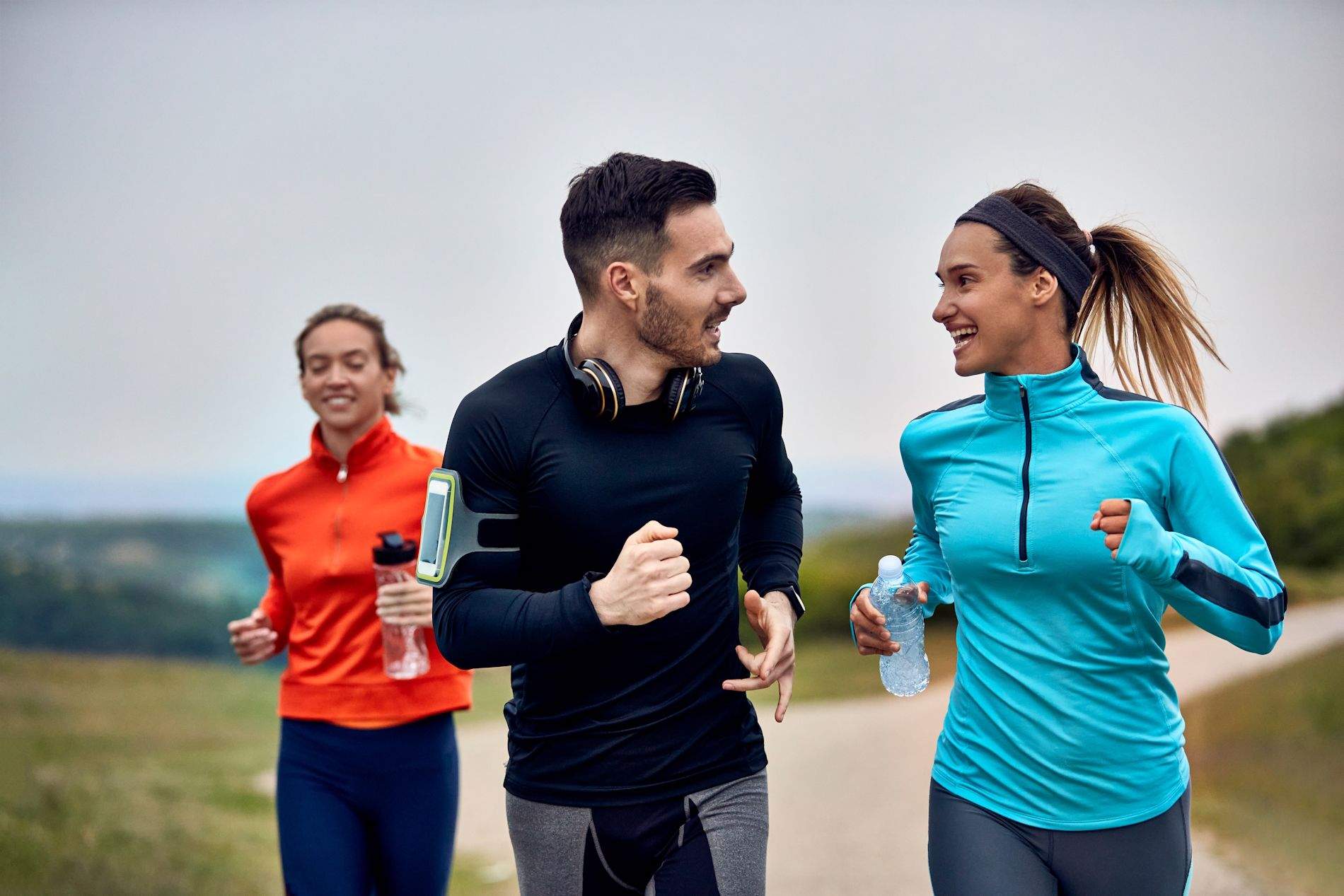 happy athletic couple communicating while taking part marathon nature 1900x1267