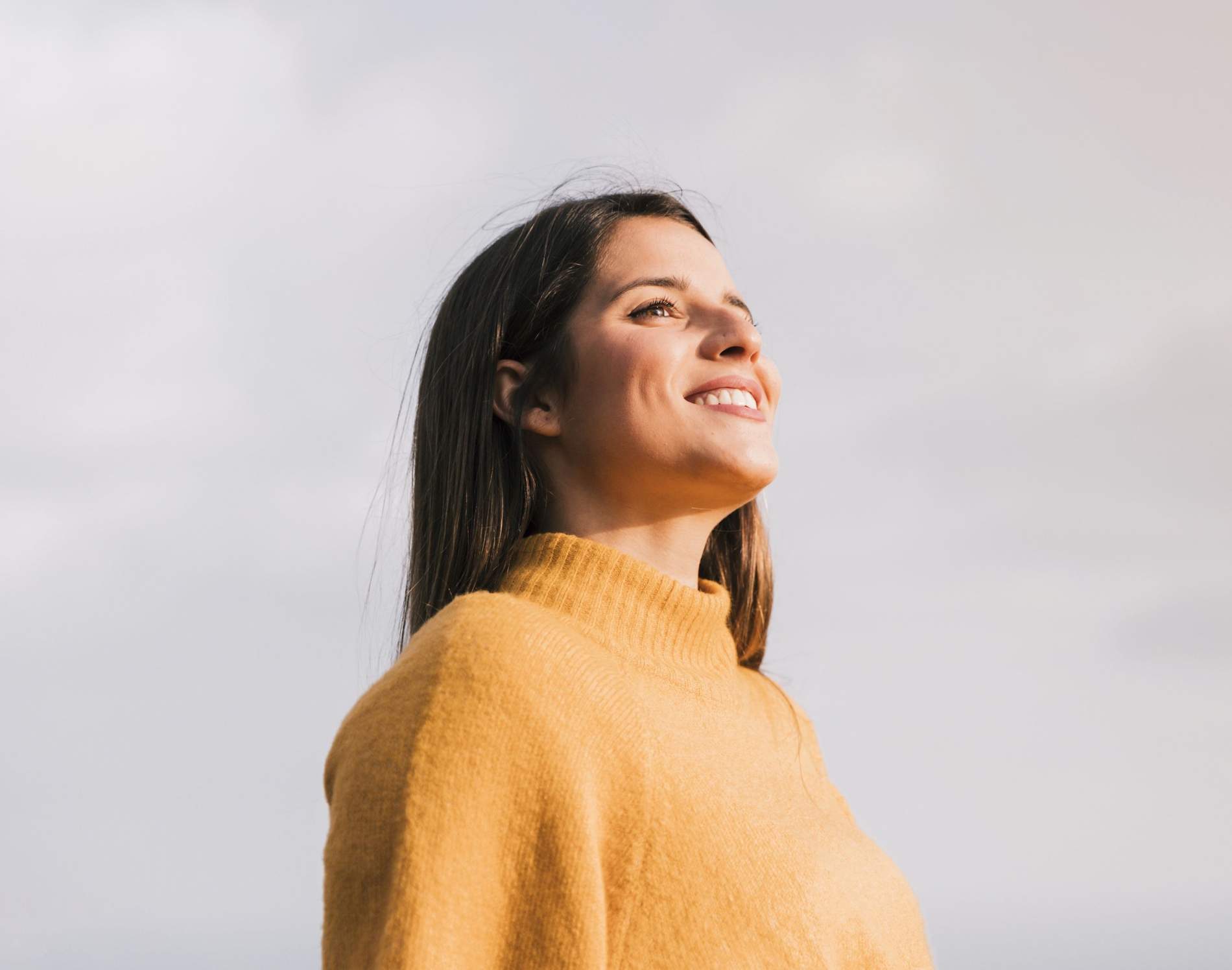 smiling young woman standing against sky looking away 4096x2731