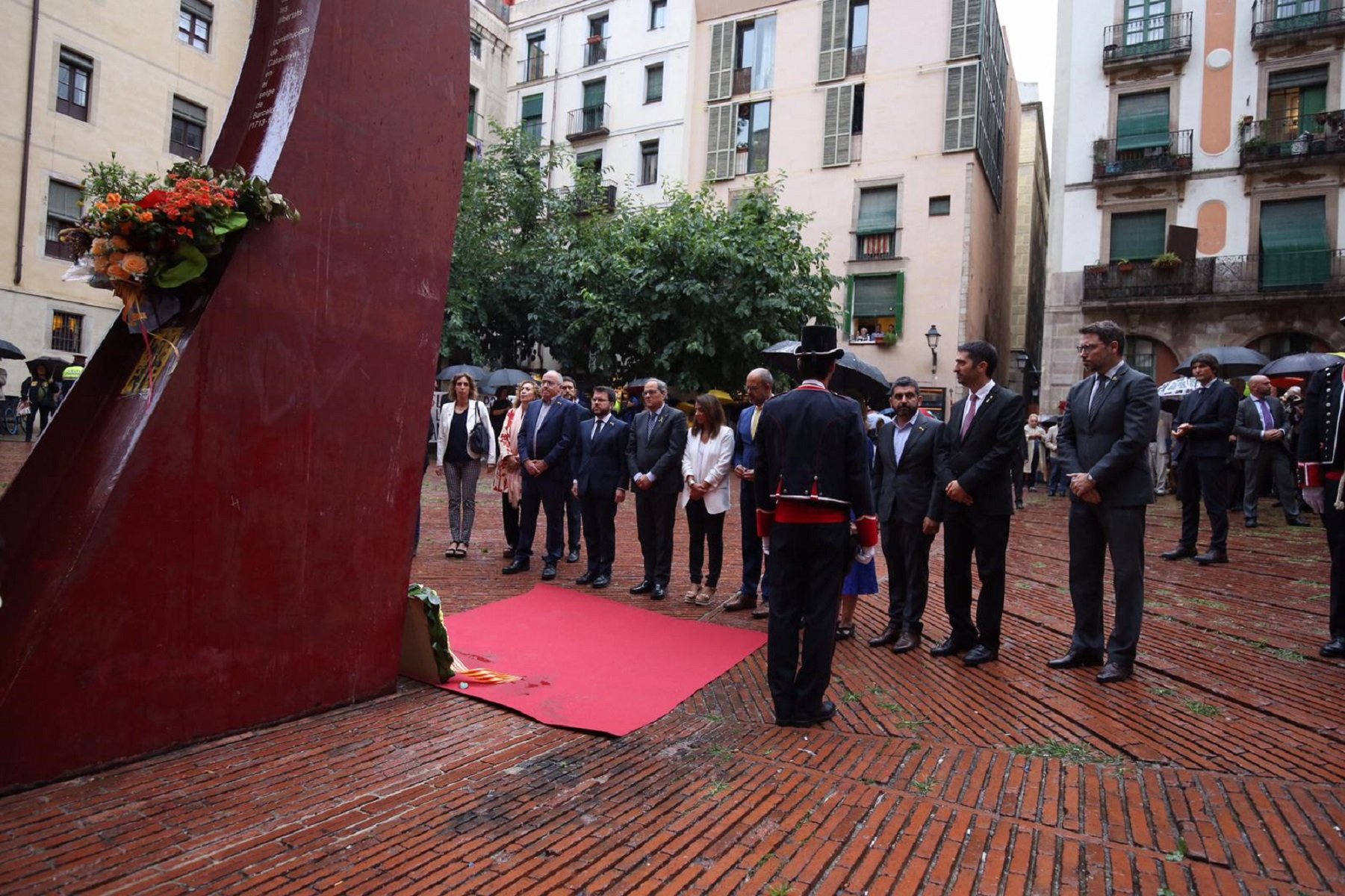 Torra y los consellers hacen bajo la lluvia la ofrenda floral en el Fossar de les Moreres