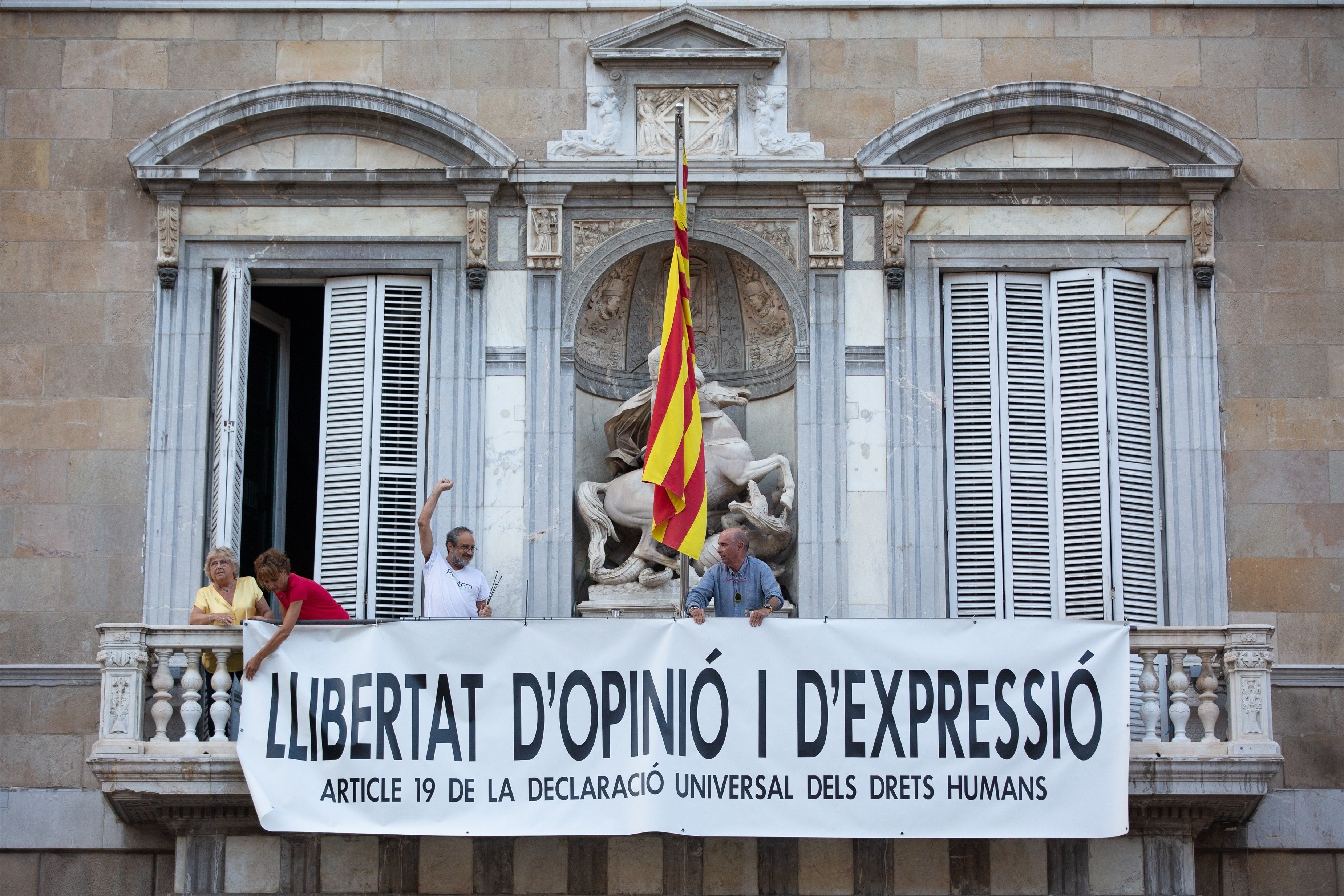 Llach, Bel y Baños cuelgan una nueva pancarta en el balcón de la Generalitat